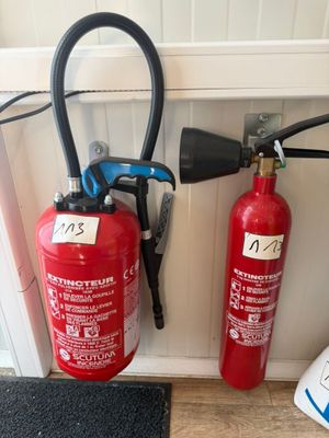 two fire extinguisors next to each other on the floor