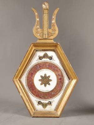 une horloge dorée et rouge surmontée d'un oiseau
