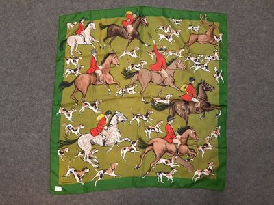 un gros plan sur une écharpe verte ornée de chevaux et de chiens