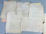 several old manuscripts are on a table with papers and papers