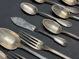 a lot of silver spoons and forks on the table