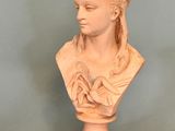 marble bust of a woman with braid hair on a pedestal