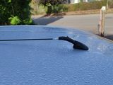 un gros plan du capot d'une voiture sur lequel est fixée une antenne
