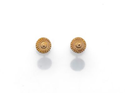 une paire de boucles d'oreilles en or sur fond blanc