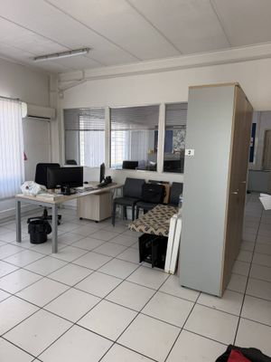 un sol carrelé de blanc dans une pièce où se trouvent un bureau et deux écrans d'ordinateur