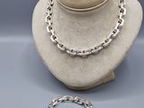 un ensemble composé d'un collier et d'un bracelet en argent, présenté sur un mannequin