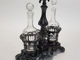 pair of black glass decanters on stand on white background