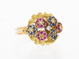 a close up of a gold ring with blue, pink and white stones
