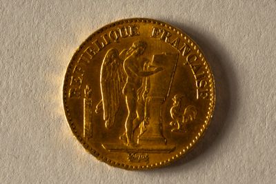 une image d'une pièce d'or sur une surface blanche