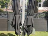deux parapluies posés sur un mât dans l'herbe
