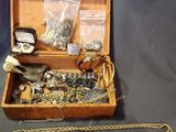 a wooden box filled with jewelry on a table