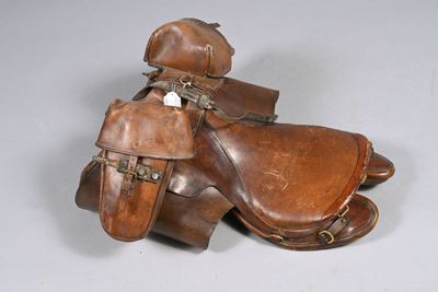 une paire de selles en cuir sur fond gris