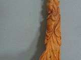 someone is holding a small carved object in their hand