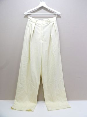 Le pantalon blanc est suspendu à un cintre contre le mur.