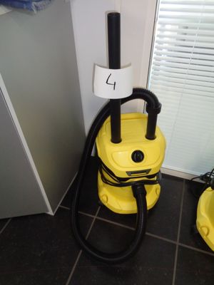 a yellow vacuum sitting on the floor next to a yellow bucket