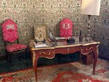 deux chaises et un bureau dans une pièce au papier peint à motifs floraux