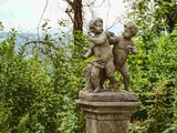 une statue représentant un garçon et un chien, posée sur un socle