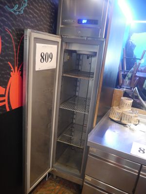 un réfrigérateur situé à côté d'un comptoir sur lequel est accrochée une pancarte