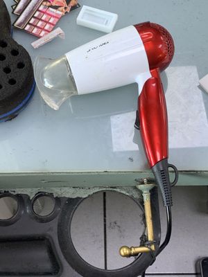 un sèche-cheveux rouge posé sur une table