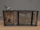 an old television sitting on a table with a knife sticking out of it
