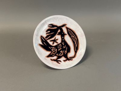 a close up of a white plate with a dragon on it