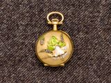 une petite montre de poche en or ornée d'un oiseau