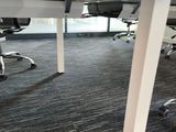 a room with a desk, chairs, and a laptop on it