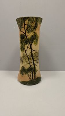 a vase with a painting on it sitting on a table