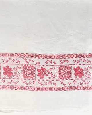 une serviette blanche ornée d'un motif floral rouge