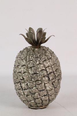a silver pineapple sitting on a white surface