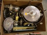 a cardboard box full of silver items on the floor
