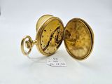 an image of a gold pocket watch sitting on top of a white table