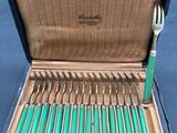 many forks and spoons in a case on the table