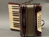 an old accordion sitting on top of a table next to a bag of luggage