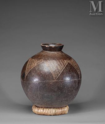 a brown vase sitting on top of a wooden stand