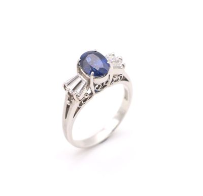a close up of a ring with a sapphire and diamonds