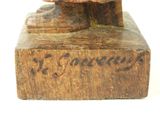 a wooden statue of a man with a hat on