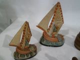 two figurines of a cat and a sailboat on a table