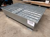 une photo d'une table basse en acier et en verre dans un entrepôt