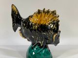 ceramic figurine of a fish on a green base