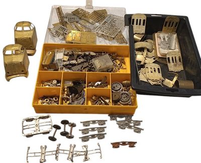 une boîte remplie d'objets métalliques variés posée sur une surface blanche