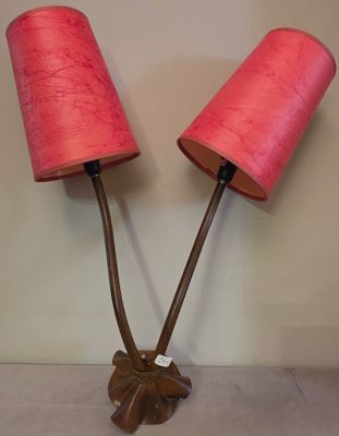 une paire de lampes roses ornées de feuilles, posées sur une table