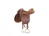 une selle marron sur laquelle sont fixés une selle et un étriers