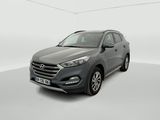 the front view of a grey 2017 hyundai tucson parked in a white room