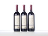three bottles of red wine sitting on top of a white table