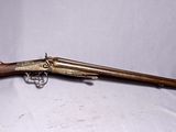 un vieux pistolet avec une crosse en bois et un étui vert