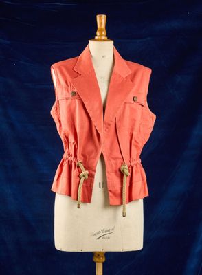 une veste orange sur un mannequin, sur fond bleu