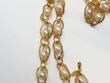 necklace with pearls and gold chain on a white surface