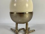 an image of a white egg sitting on top of a metal stand