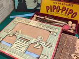 une table sur laquelle se trouvent divers objets, notamment un jeu de société et une paire de ciseaux